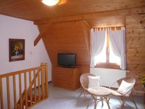 sala de estar con TV, mesa y sillas en A l'Ancien Moulin, en Gertwiller