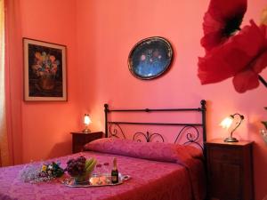 una camera da letto con pareti arancioni e un letto con un piatto di frutta di Xanadu - Villa Giardinata a Valderice