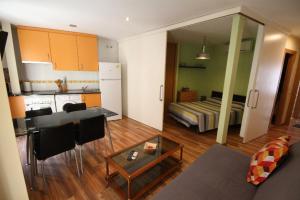 托萊多的住宿－Alojamientos Toletvm，厨房以及带沙发和桌子的客厅。