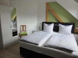 ein Schlafzimmer mit einem großen Bett und einer grünen Wand in der Unterkunft Feriendomizil Taupadel in Bürgel