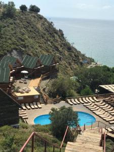 um resort com duas piscinas e cadeiras junto ao oceano em Ayanya Beach Hotel & Bungalows em Avsa Adasi