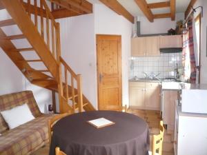 eine Küche und ein Wohnzimmer mit einem Tisch im Zimmer in der Unterkunft A l'Ancien Moulin in Gertwiller