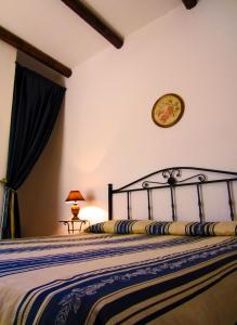 un letto in una camera da letto con un orologio a muro di Xanadu - Villa Giardinata a Valderice