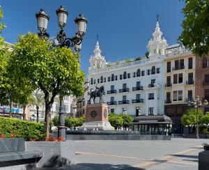 un edificio con una estatua en medio de una calle en H10 Palacio Colomera, en Córdoba