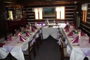 a long dining room with white tables and chairs at Pension Alex in Benecko