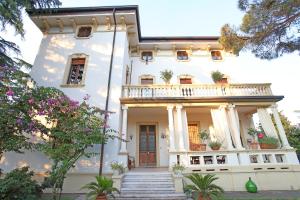 een groot wit huis met een balkon bij Il Bozzolo Eco Boutique Apartments in Valeggio sul Mincio