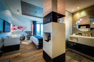 a room with a bed and a bathroom with a sink at Royal Beach Hotel Tel Aviv by Isrotel Exclusive in Tel Aviv