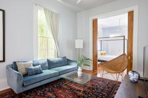 a living room with a blue couch and a mirror at Sonder at Uptown in New Orleans