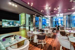 a restaurant with tables and chairs and a bar at Royal Beach Hotel Tel Aviv by Isrotel Exclusive in Tel Aviv