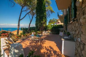 a patio with tables and chairs and the ocean at Croce Suite with Terrace in Porto Santo Stefano