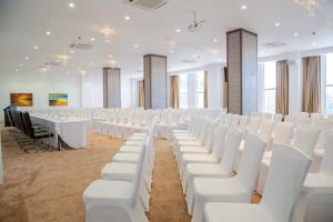 une rangée de chaises et de tables blanches dans une pièce dans l'établissement Amaryllis Hotel Blantyre, à Blantyre