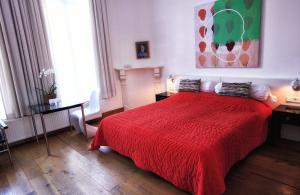 a bed room with a red bedspread and a red wall at Galerie Hotel Dis in Maastricht