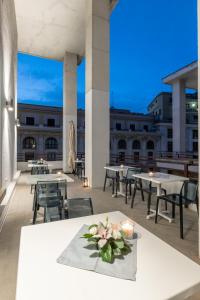 a balcony with tables and chairs on a building at Concept Terrace Hotel in Rome