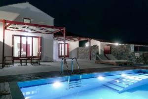 a swimming pool in a house at night at ANEFANTI VILLAS in Agios Kirykos