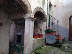 um edifício com vasos de plantas ao lado em Il Borgo 19 em Scapoli