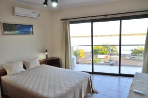 a bedroom with a bed and a large window at NorthBeach ::: Dpto. 7 in Colón
