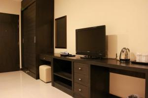 a living room with a television on a desk at The Atrium Ratchada 13 in Bangkok