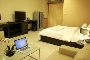 a hotel room with a bed and a laptop on a table at The Atrium Ratchada 13 in Bangkok