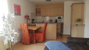 uma cozinha com uma mesa de madeira e cadeiras vermelhas em Pension Moserhaus em Harburg