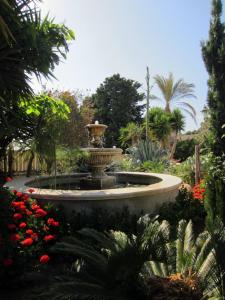 una fuente en medio de un jardín con flores en Xanadu - Villa Giardinata, en Valderice