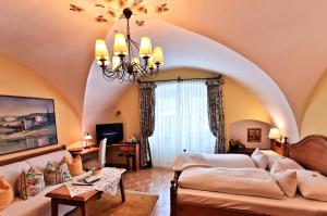 un soggiorno con un divano e un lampadario di Hotel Schrannenhof a Klosterneuburg