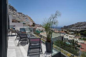 a balcony with chairs and a view of the city at The One Luxury Apartments in Puerto Rico de Gran Canaria