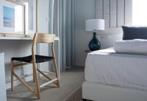 a chair sitting next to a bed in a bedroom at YOU & CO. Saler Beach Boutique in Valencia