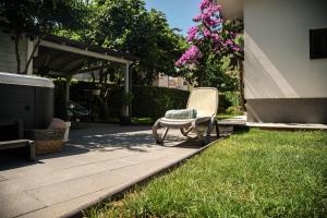 una sedia seduta sull'erba in un cortile di Apartments Medora a Rovigno (Rovinj)