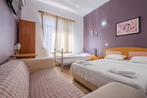 two beds in a room with purple walls at Efsali Hotel Kaleiçi in Antalya