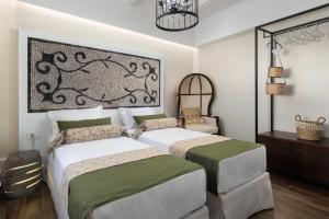 1 dormitorio con 2 camas y lámpara de araña en Casa Pietra Lindos Luxury Traditional House en Lindos
