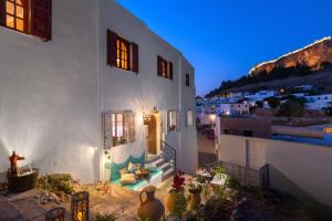 a white house with a staircase leading to a porch at Casa Pietra Lindos Luxury Traditional House in Lindos