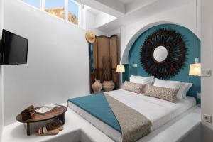 a bedroom with a bed and a mirror and a table at Casa Pietra Lindos Luxury Traditional House in Lindos
