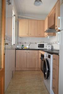 a kitchen with wooden cabinets and a dishwasher at Mar Menor Lo Pagan Apartment in San Pedro del Pinatar
