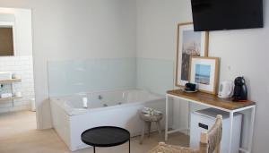 a white bath tub in a room with a table at YOU & CO. Saler Beach Boutique in Valencia