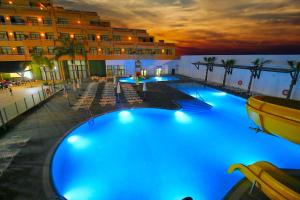 a large swimming pool with blue lights in a hotel at Advise Hotels Reina in Vera