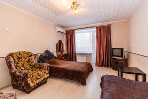 um quarto com uma cama, um sofá e uma televisão em Buzkvartira on 2 microrayon em Buzuluk