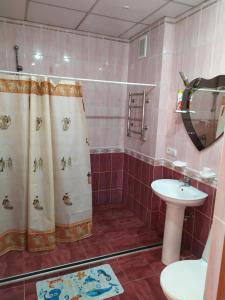 y baño con ducha y lavamanos. en Hotel Tropicana, en Svitlovodsʼk