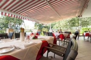 ein Esszimmer mit Tischen und Stühlen mit roten Tischdecken. in der Unterkunft Hotel Rotwand in Leifers
