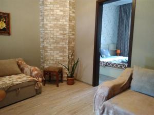 uma sala de estar com um sofá e um espelho em Nana's Apartment em Tbilisi