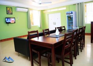 a dining room with a wooden table and chairs at DanRitzcer Suites in Accra