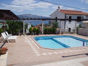 a swimming pool in a yard with a house at Apartments Romana in Slatine
