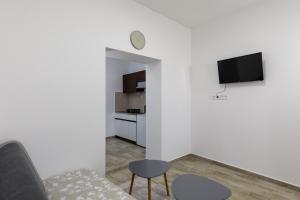 sala de estar con sofá y TV en la pared en Apartments Green Scenic en Dubrovnik
