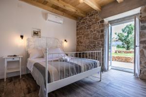 a bedroom with a bed and a stone wall at Stone Villa Katarina with pool in Klimno +27 photos