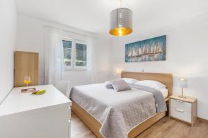 a white bedroom with a bed and a table at Apartment Niki in Opatija +36 photos