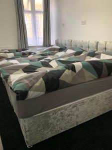 uma cama num quarto com um cobertor em Entire 6 Bed 5 Star Luxury House FREE WiFi nice views em Burnley