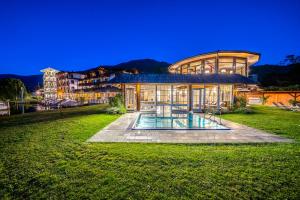 ein großes Haus mit Pool davor in der Unterkunft Romantik SPA Hotel Seefischer in Döbriach