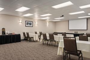 una sala conferenze con tavoli, sedie e lavagna bianca di Country Inn & Suites by Radisson, Woodbury, MN a Woodbury