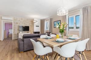 a living room with a table and chairs and a couch at Apartment Niki in Opatija