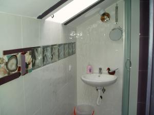 a white bathroom with a sink and a shower at Villa AdiArt in Arda