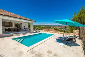 a villa with a swimming pool and an umbrella at Apartment Niki in Opatija